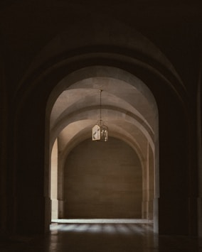 Arches of a corridor with a hanging light.