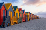 Colorful beach huts line the sandy shore.