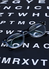 Glasses sit on an eye chart.