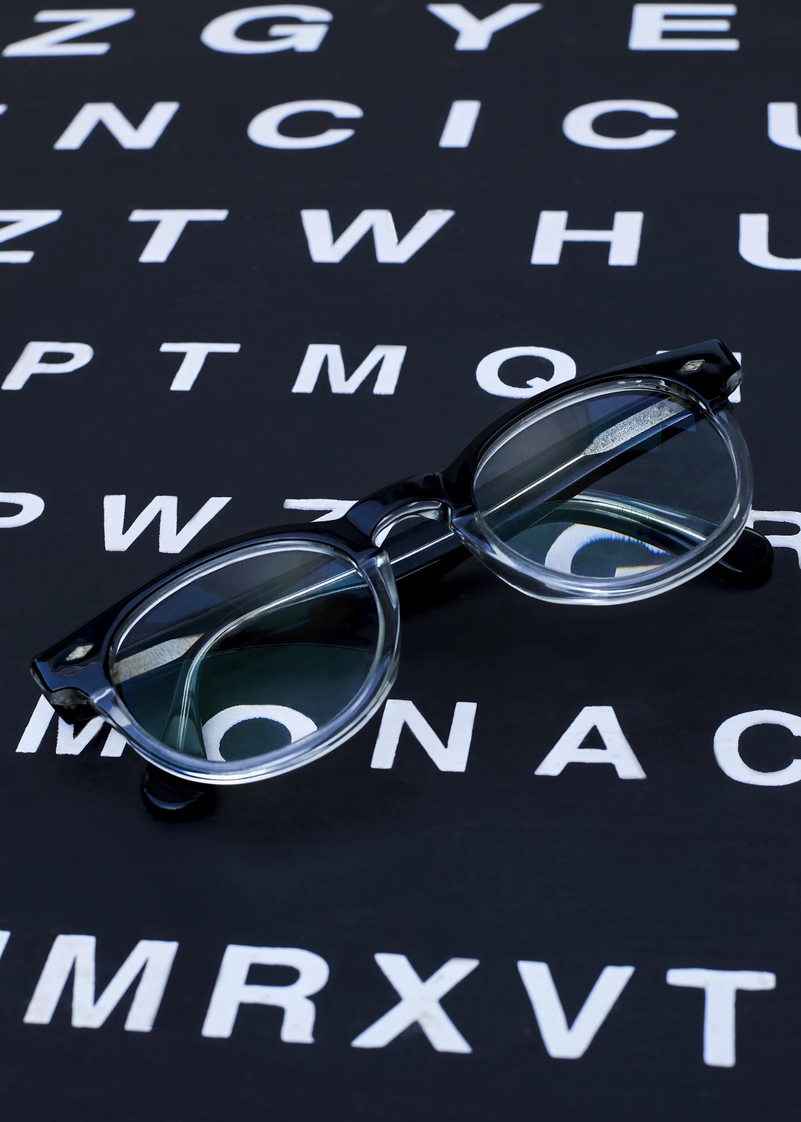 Brille liegt auf einer Sehtafel – Augenmessung bei Optik Sauter