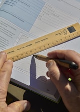 Someone is drawing a graph with a ruler and pen.