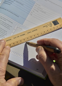 Someone is drawing a graph with a ruler and pen.