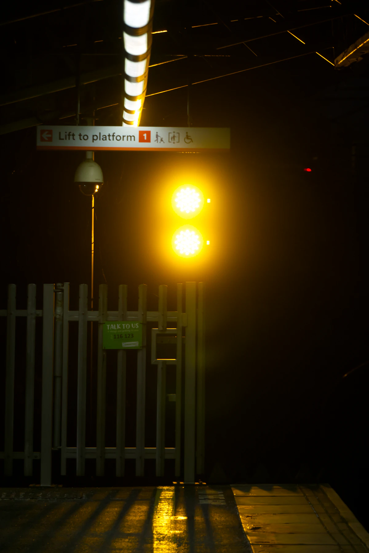 Passengers waiting on a British railway station platform as a train arrives