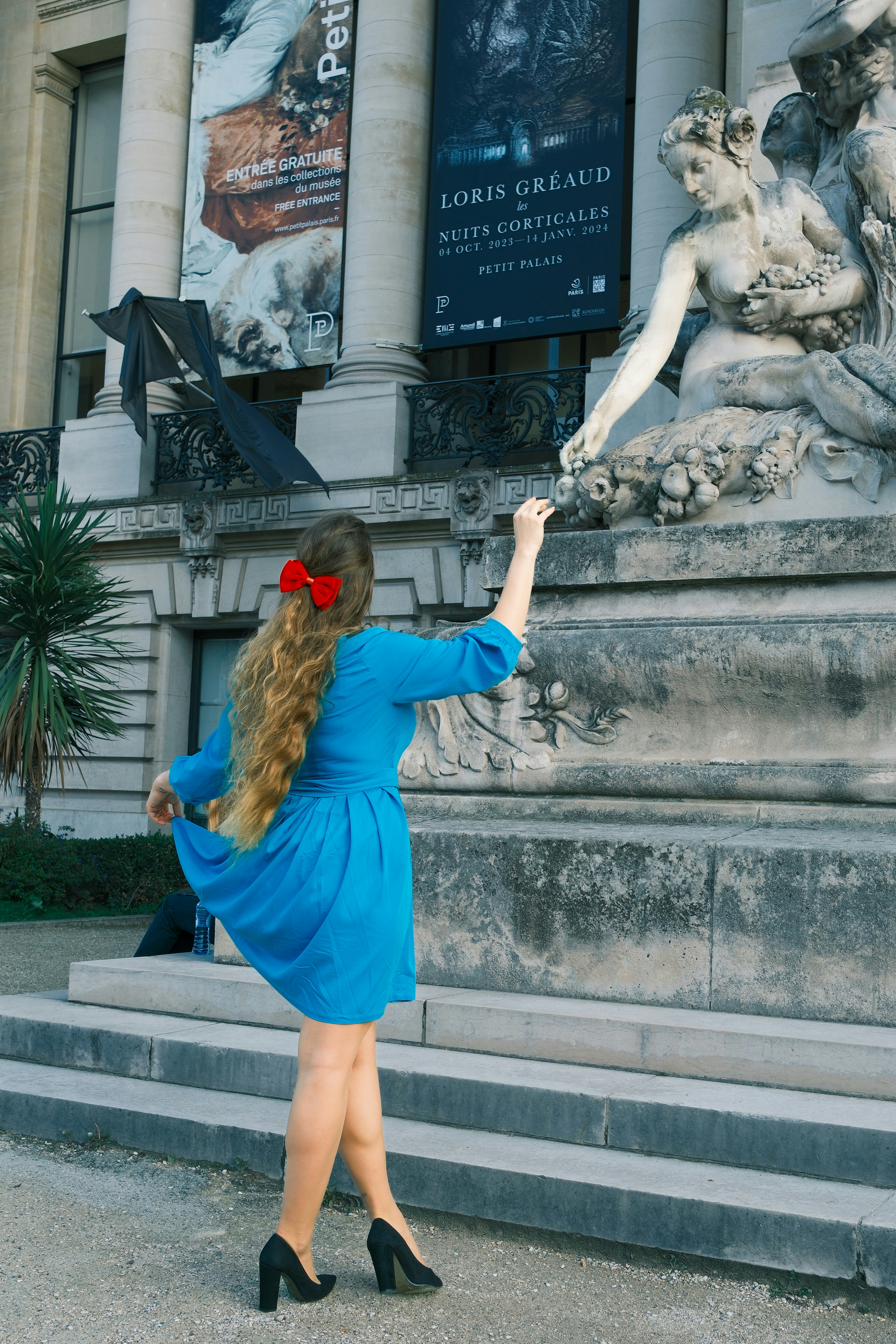 Woman in blue dress poses with a statue. photo – Free Blue Image on ...