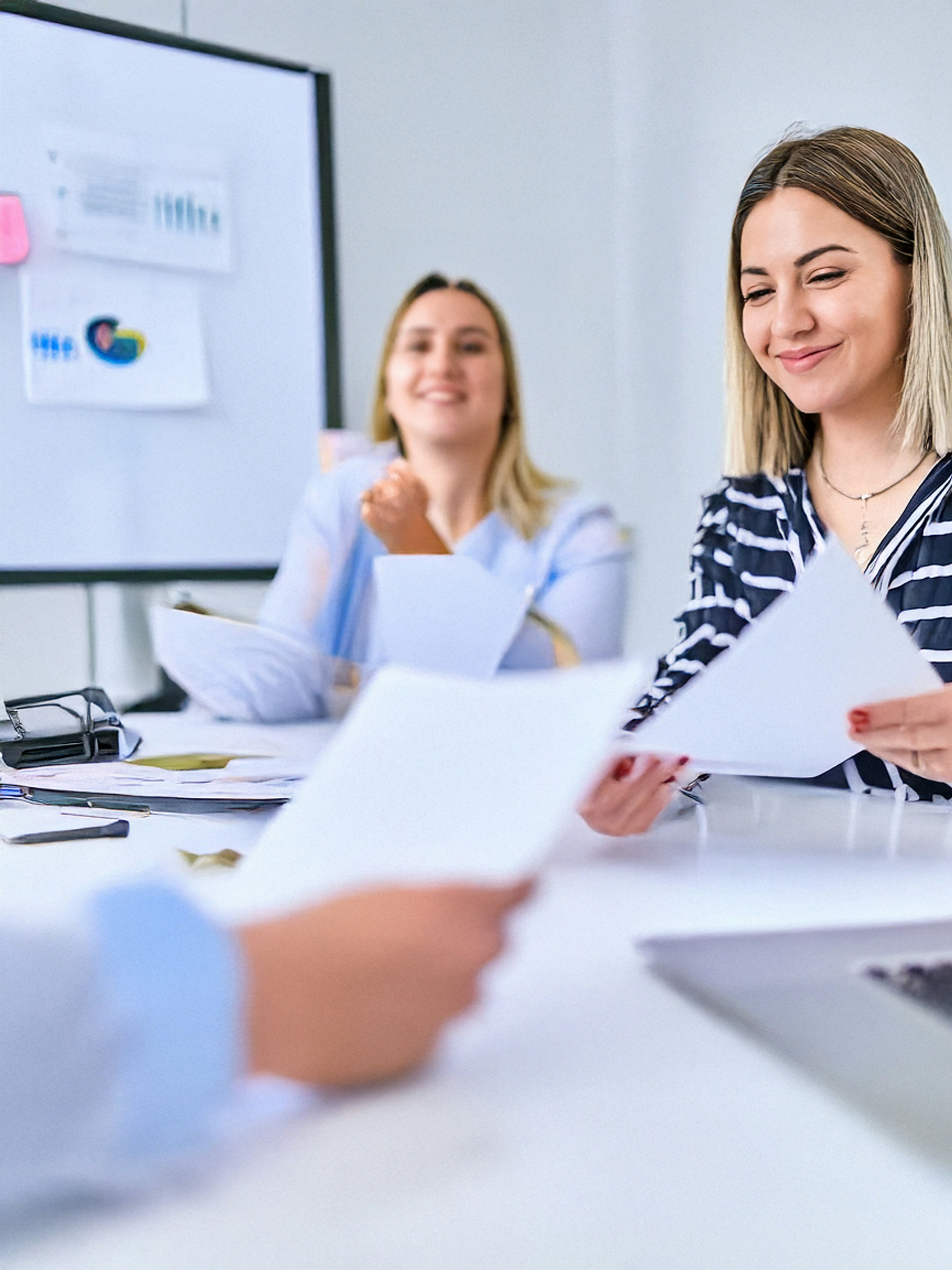 People review documents in a bright office setting.