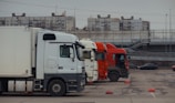 Trucks are parked in a row in a parking lot.