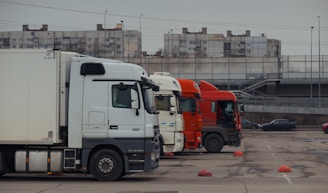 Trucks are parked in a row in a parking lot.