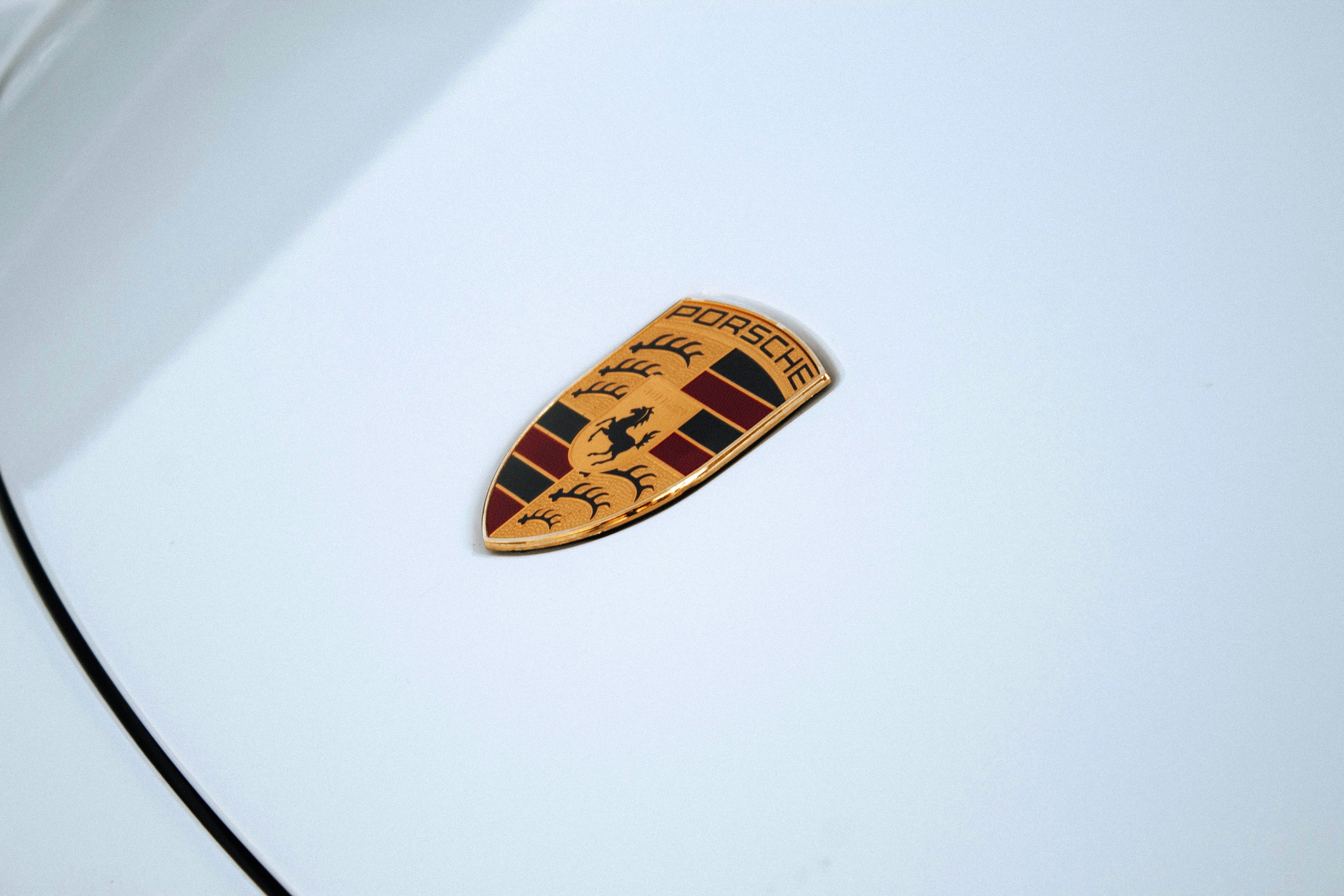 A porsche emblem on a white car.