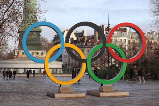 The olympic rings are prominently displayed in a city.