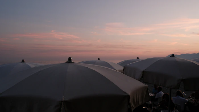Ombrelloni in spiaggia al tramonto con il cielo rosa
