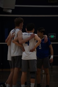 Volleyball team huddles together during a game.