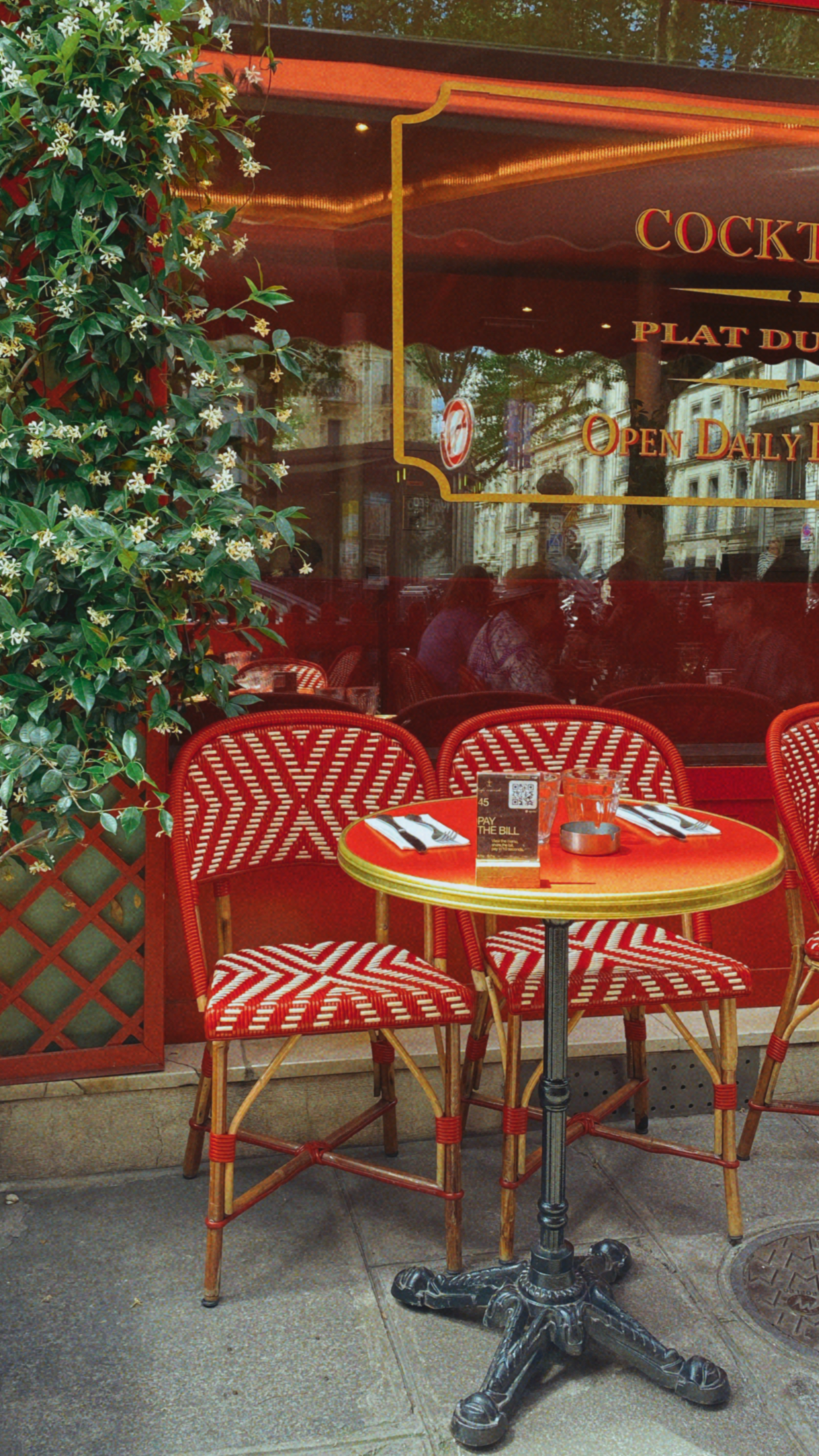 Cozy parisian cafe with red chairs and a table.