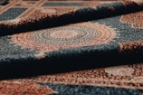 Rolled-up rug shows intricate pattern and detail.