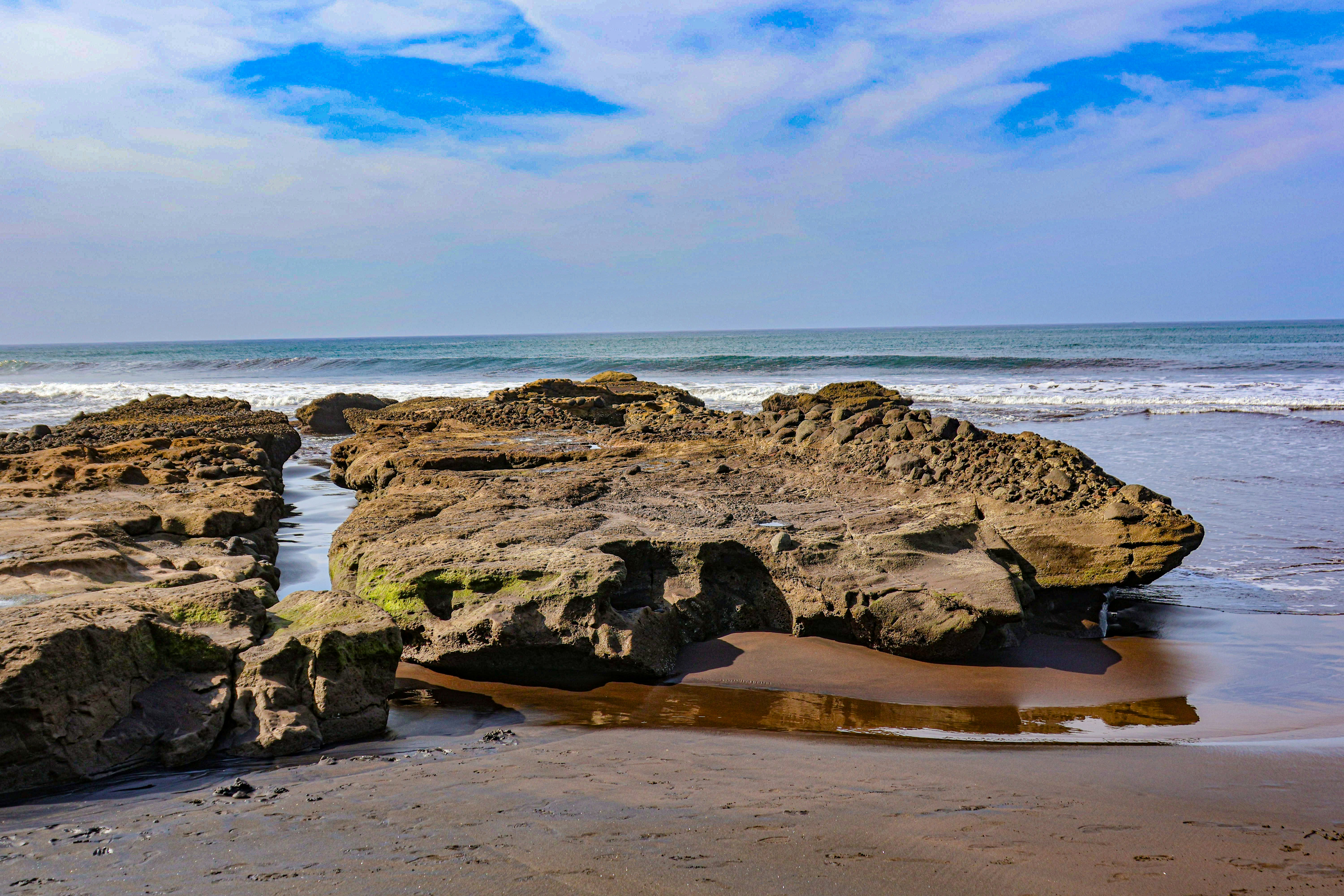 Rocky shore meets the sea under a blue sky