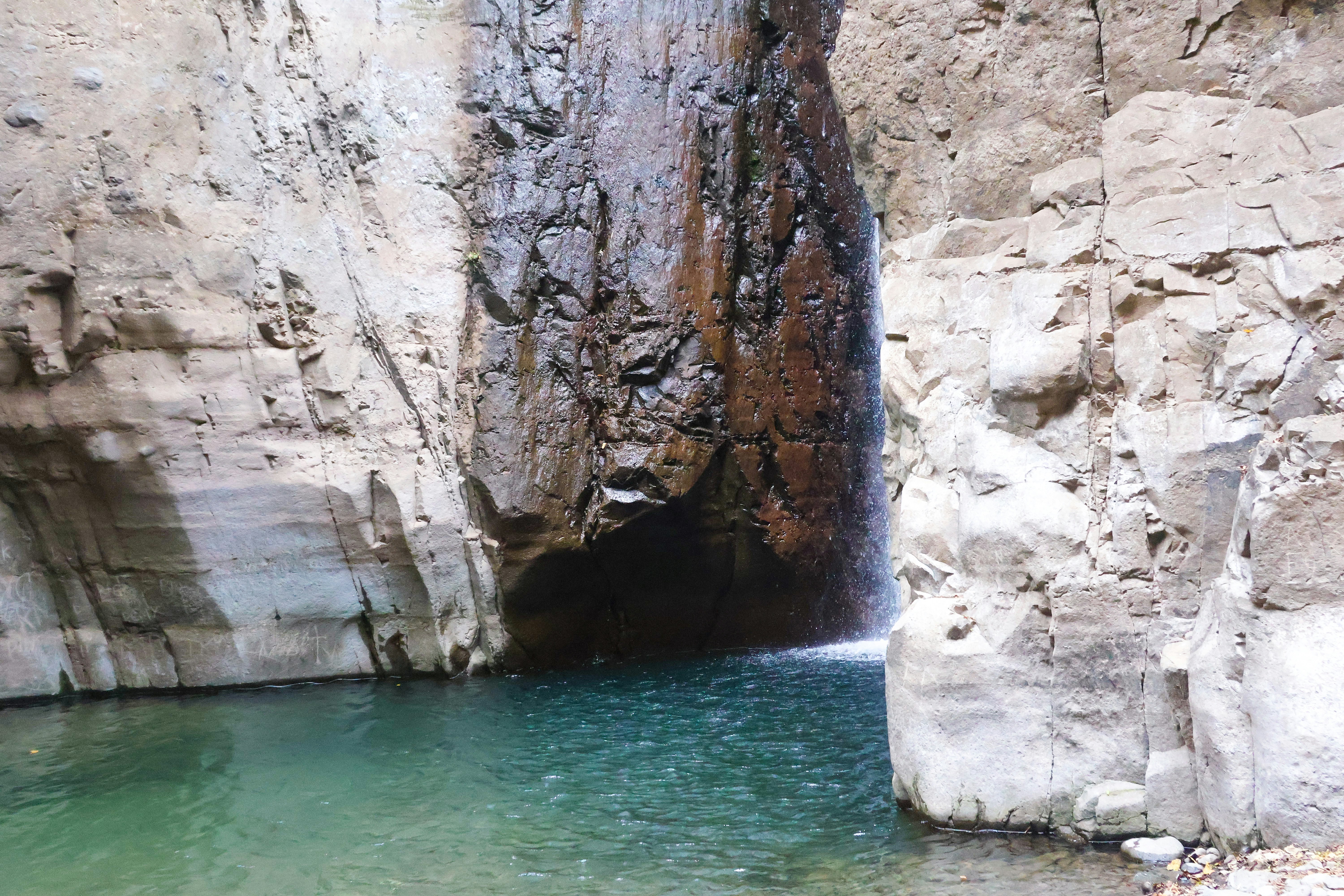 Waterfall cascades into a pool of clear water.