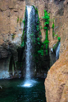 Waterfall plunges into a beautiful, dark pool.
