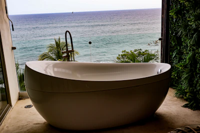 A luxurious bathtub overlooks the beautiful ocean.