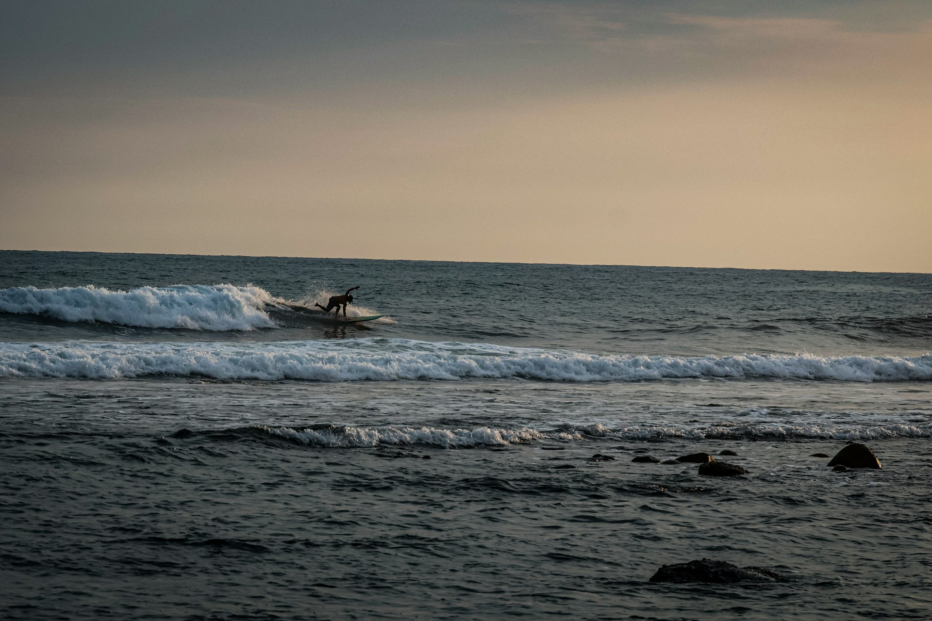 A surfer rides a wave in the ocean.