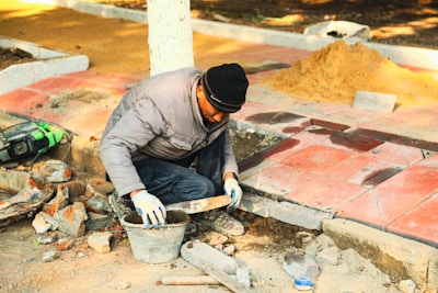 A construction worker is working on the pavement.