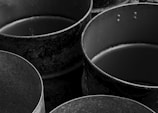 Old, empty metal containers are depicted in black and white.