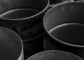 Old, empty metal containers are depicted in black and white.