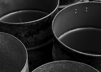 Old, empty metal containers are depicted in black and white.