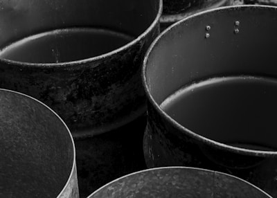 Old, empty metal containers are depicted in black and white.