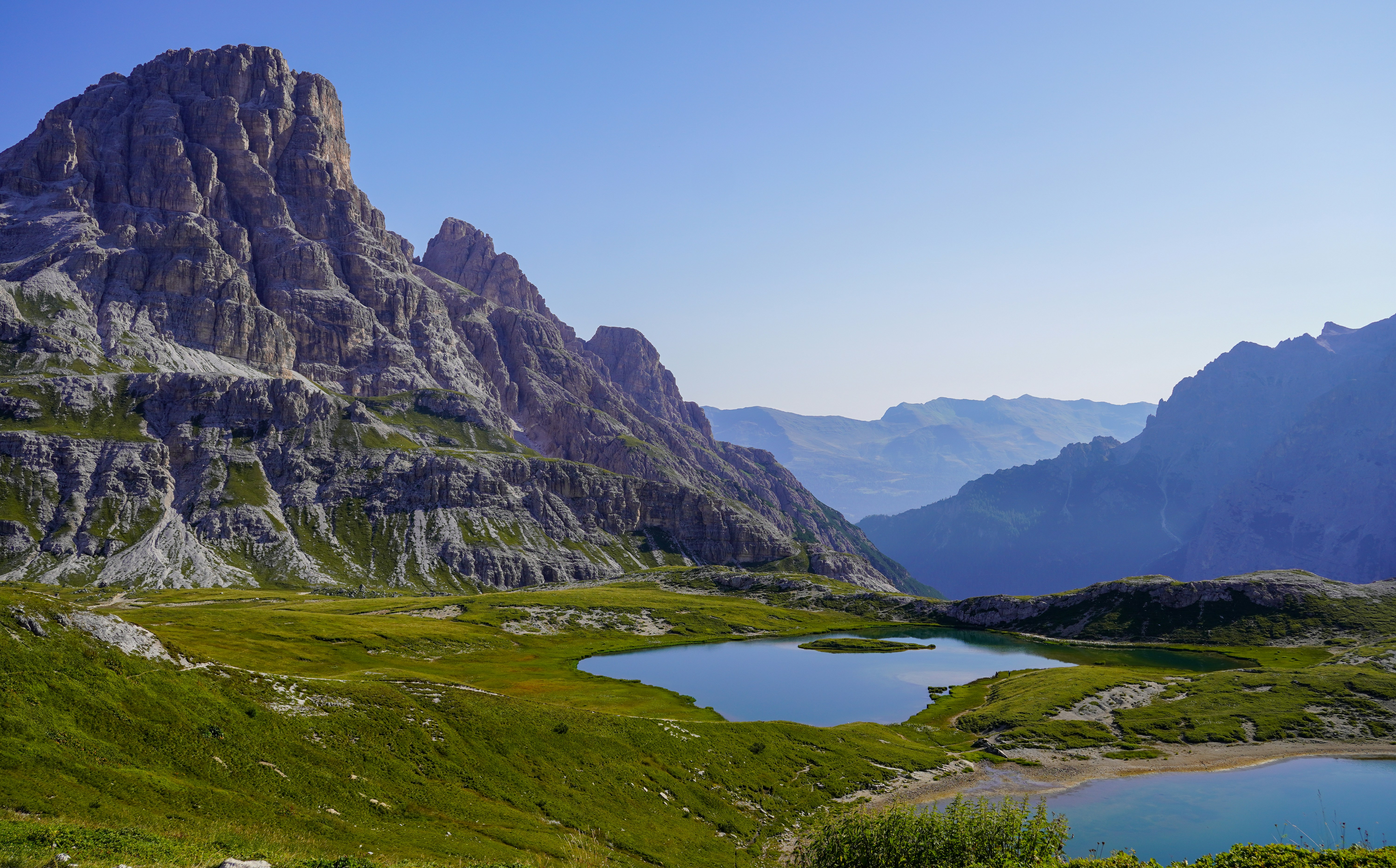 Mountain landscape with lakes under a bright blue sky.