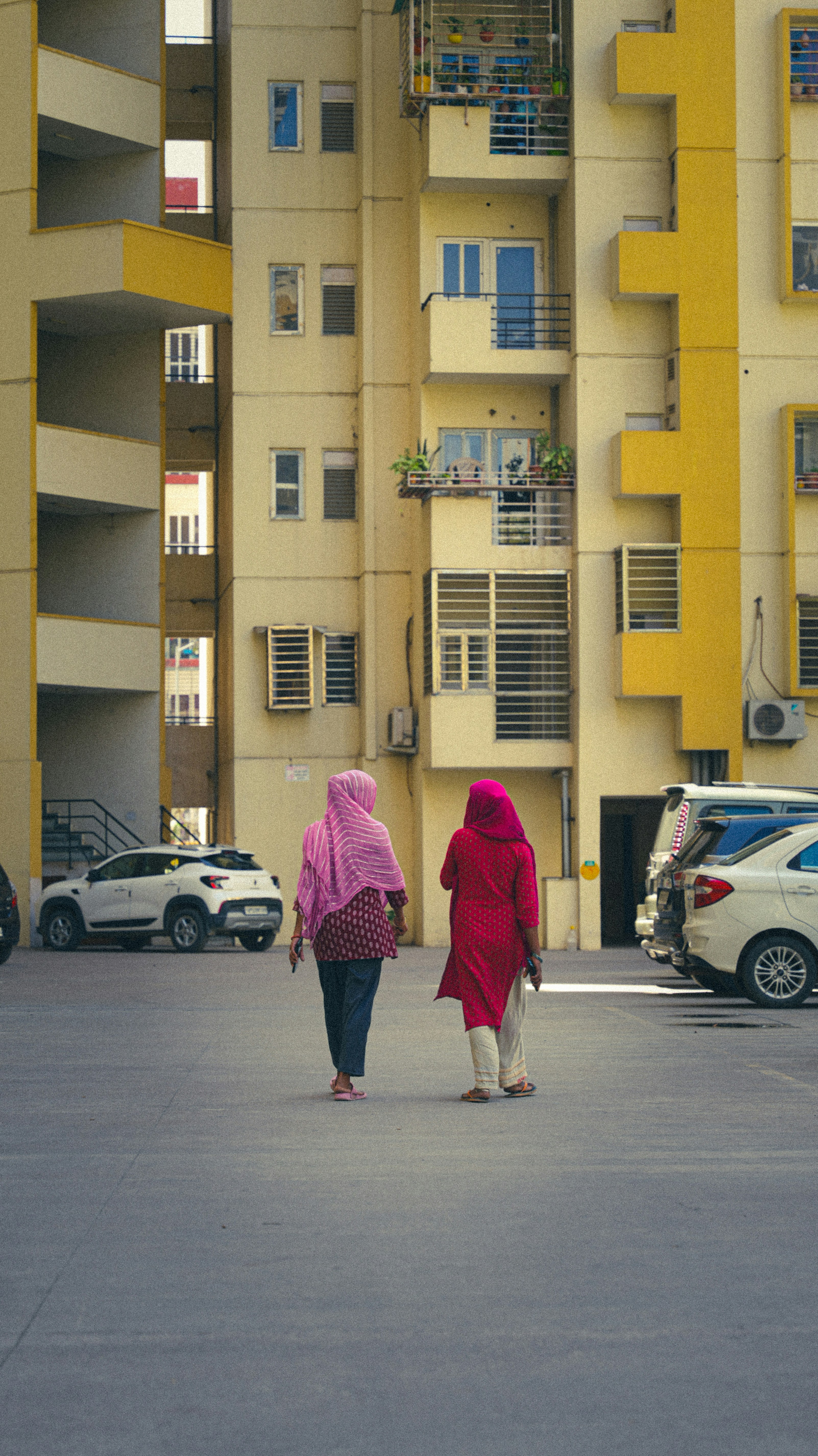 Two women walk in front of a building.