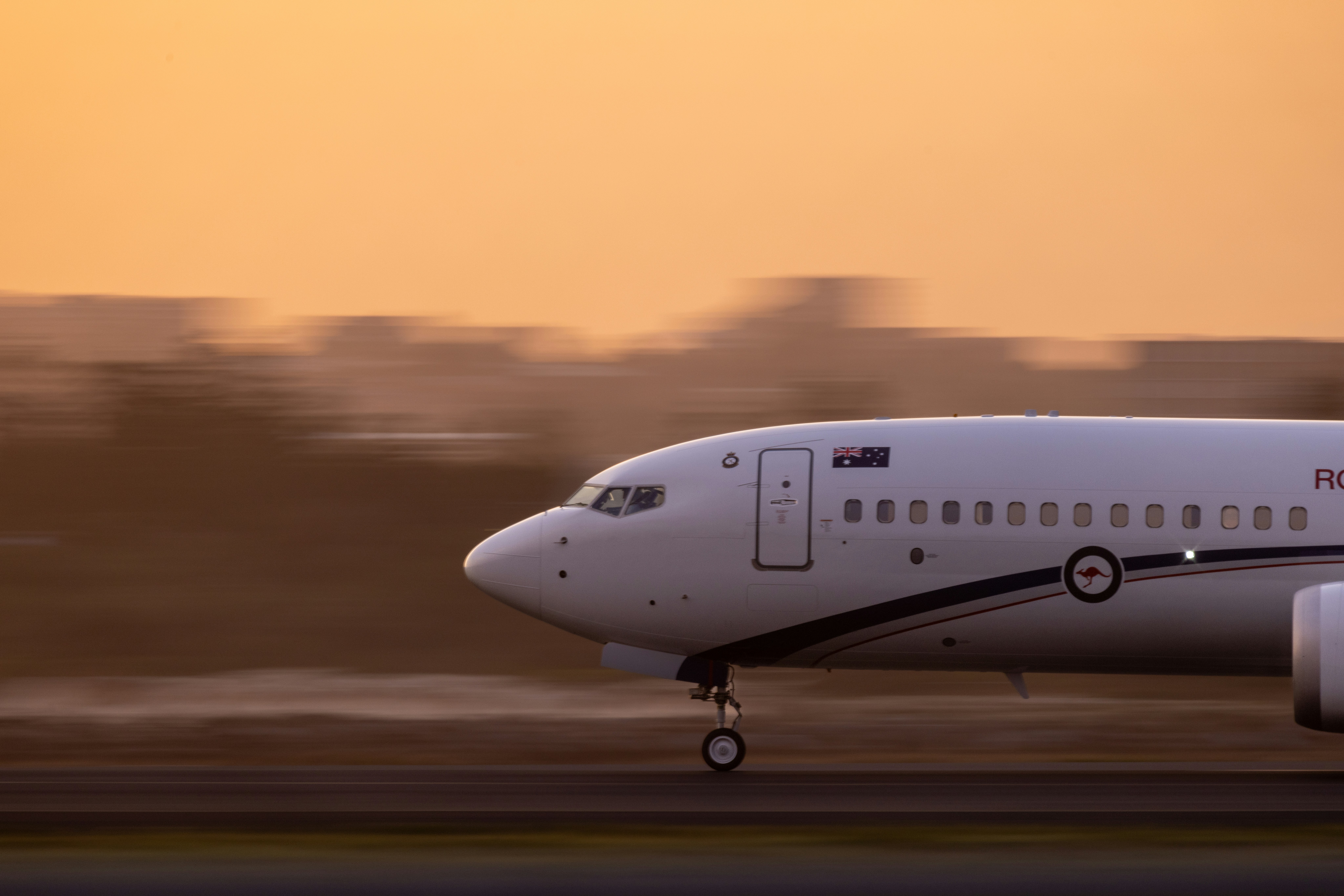 An airplane takes off during a sunrise.