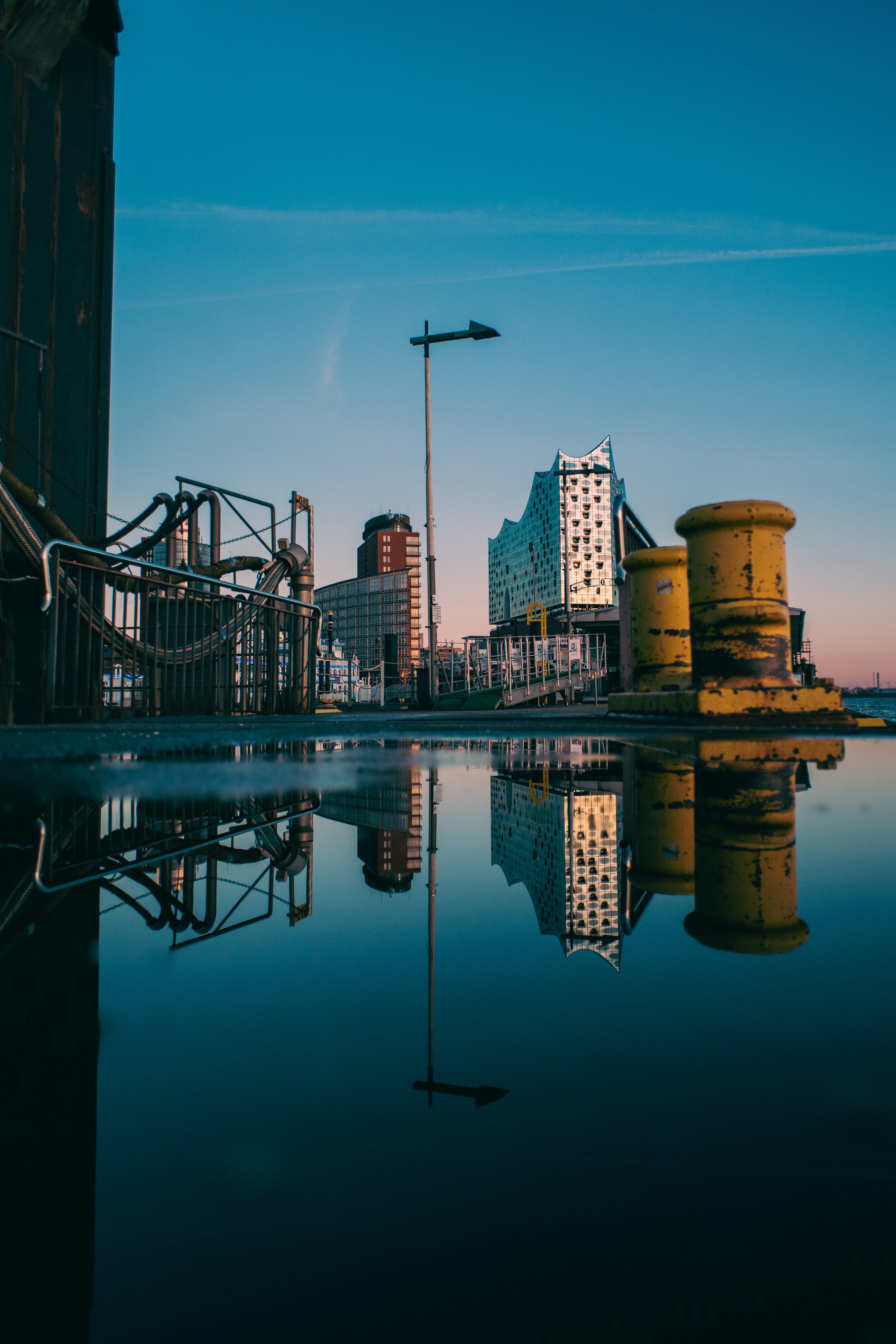 Cityscape reflects in water with a blue sky.