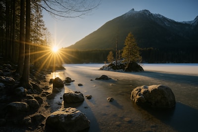 Sunrise over a mountain lake with icy rocks.