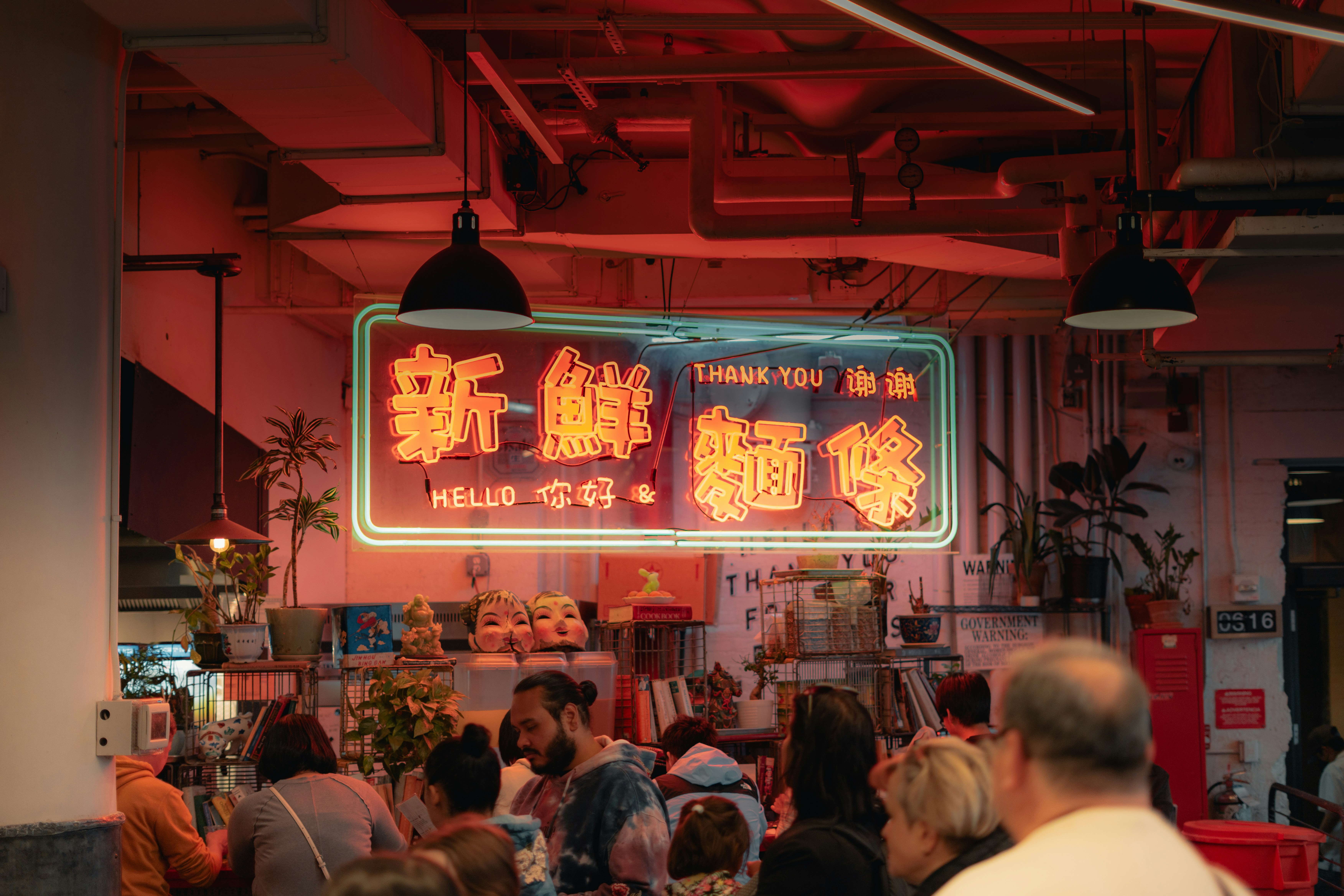 A neon sign advertises in a crowded space.