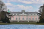 A pink palace stands gracefully beside the water.