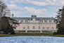 A pink palace stands gracefully beside the water.