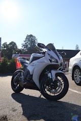 A white honda cbr motorcycle is parked on the road.