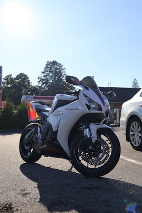 A white honda cbr motorcycle is parked on the road.