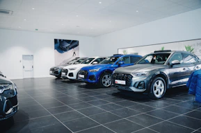 Cars are lined up in a showroom.