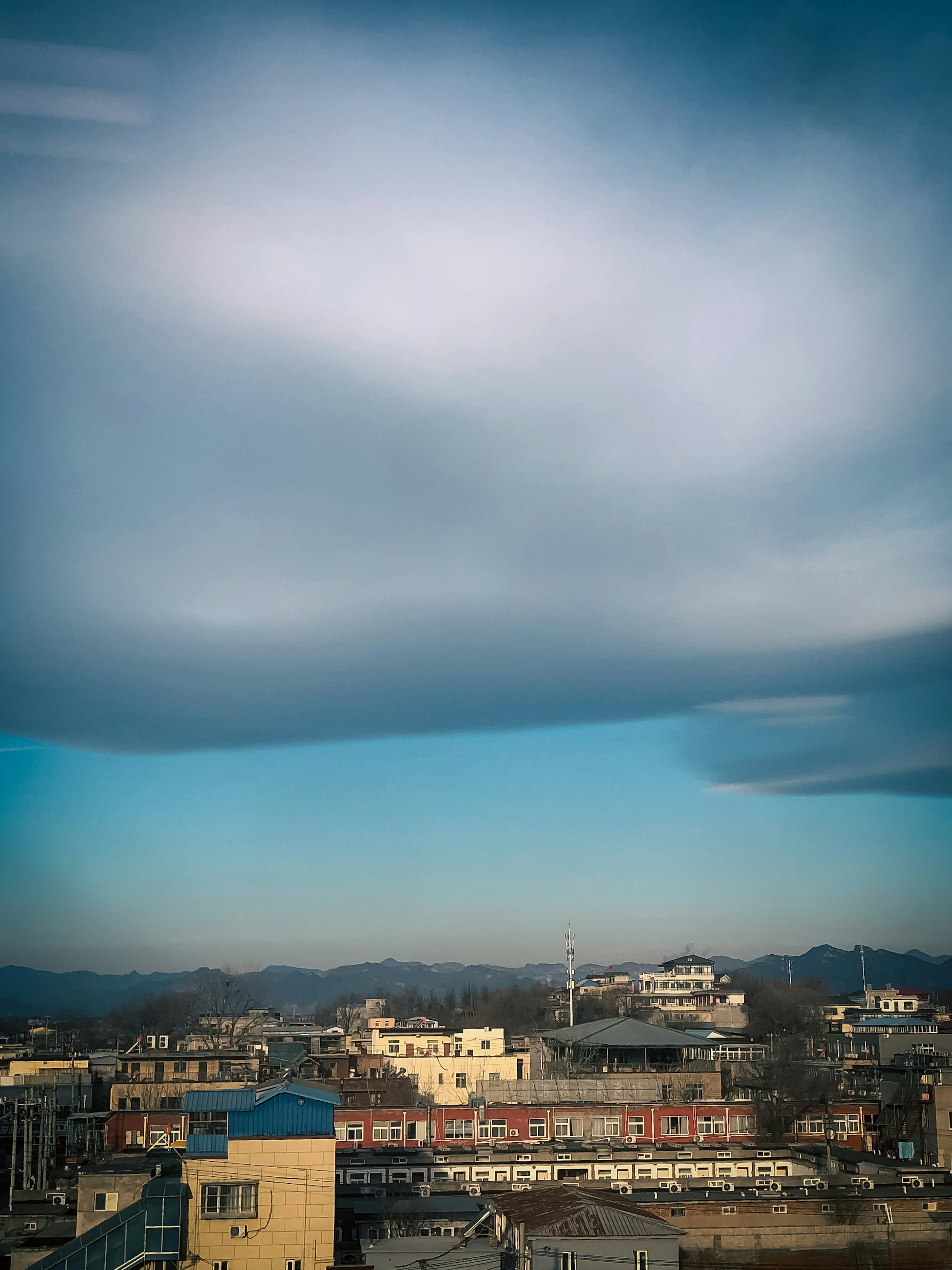 City buildings are below a large, cloudy sky.