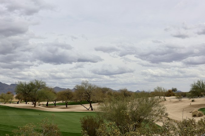 A golf course under a cloudy sky, similar to the DragonRidge Country Club course at the center of Henderson's MacDonald Highlands