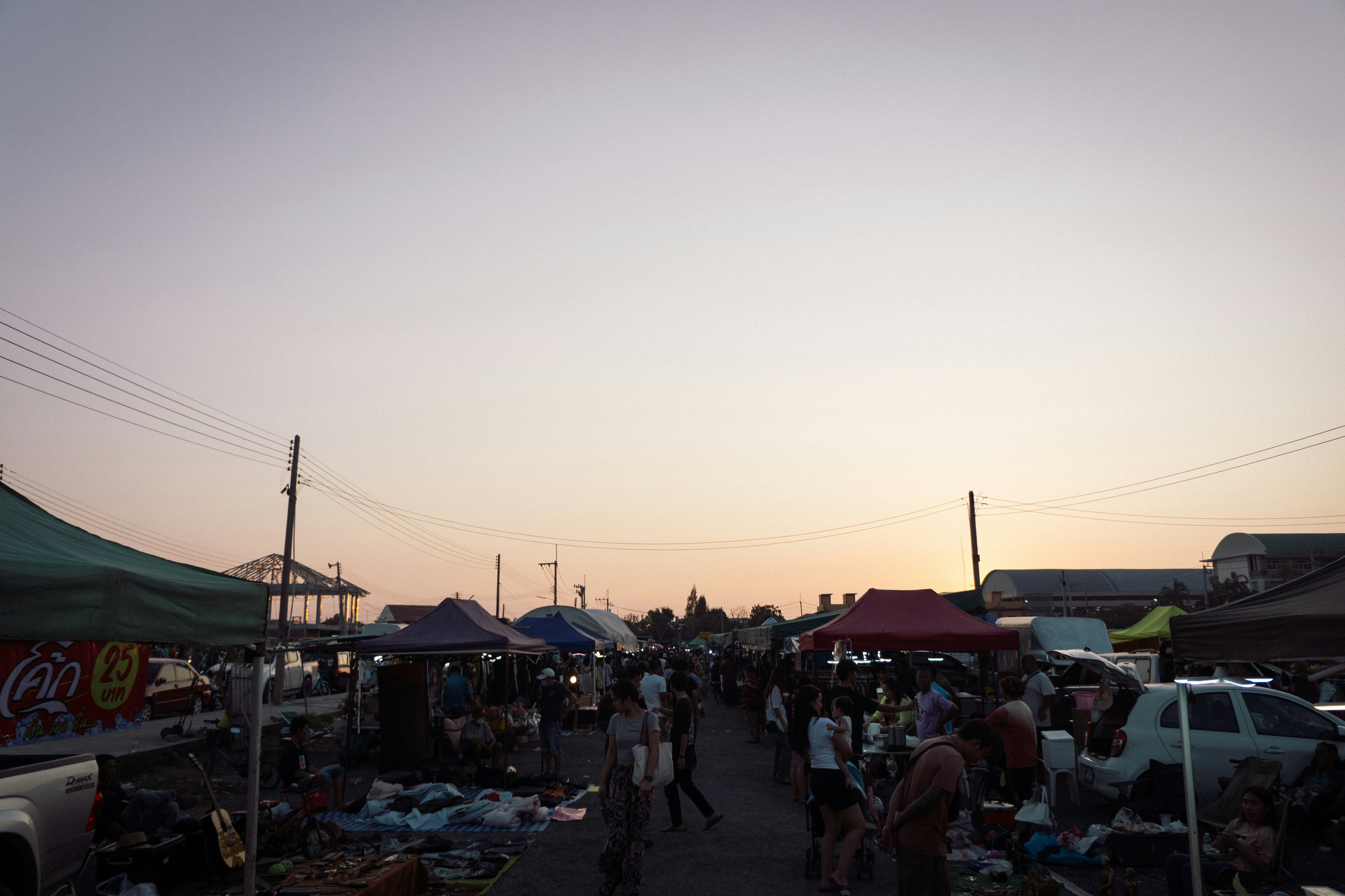 A busy outdoor market scene at dusk.
