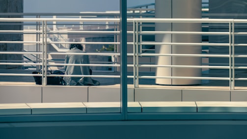 Person standing near a railing reflected in the window.