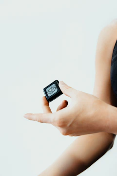 A person holds a small, black device