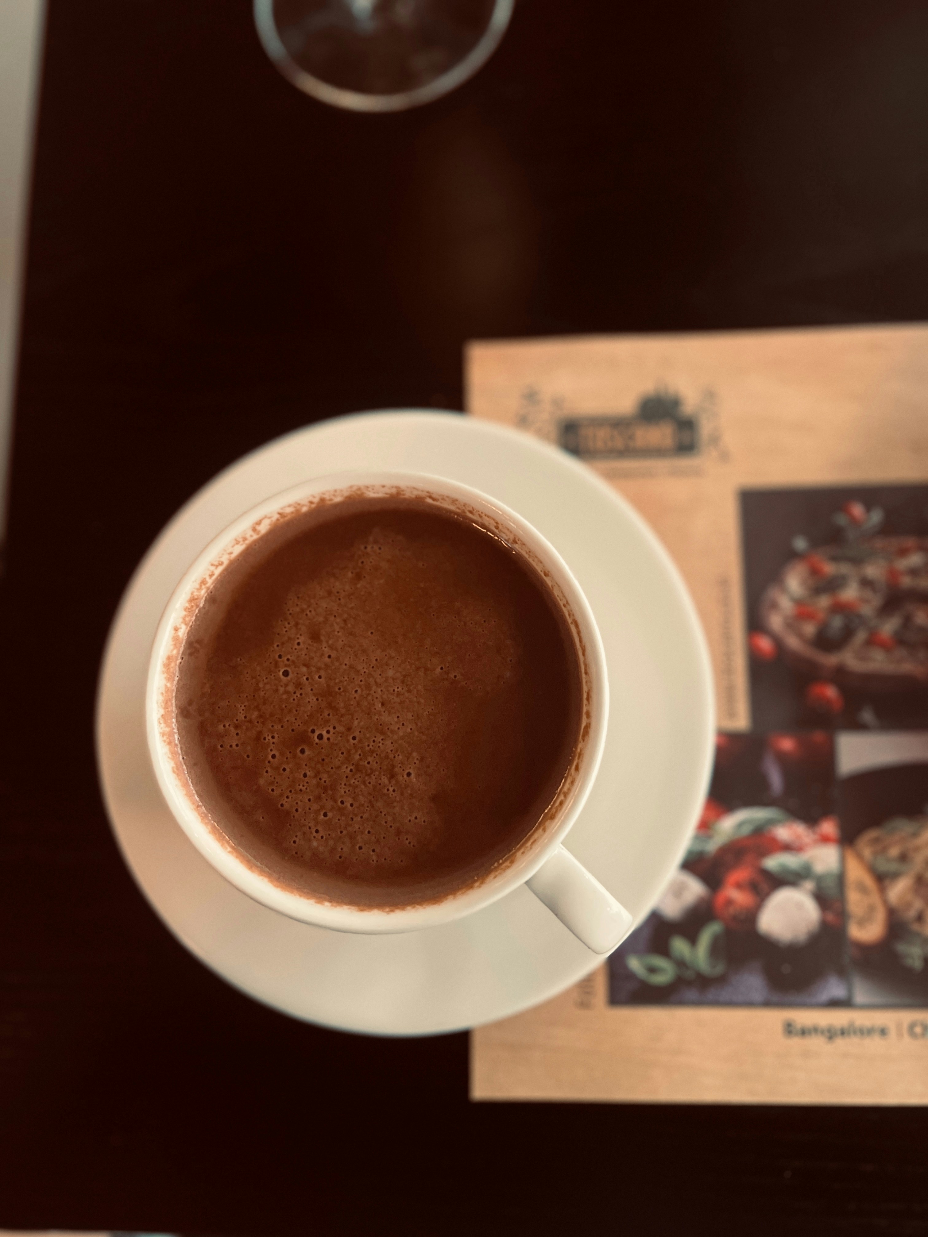 A cup of hot chocolate rests on a saucer.