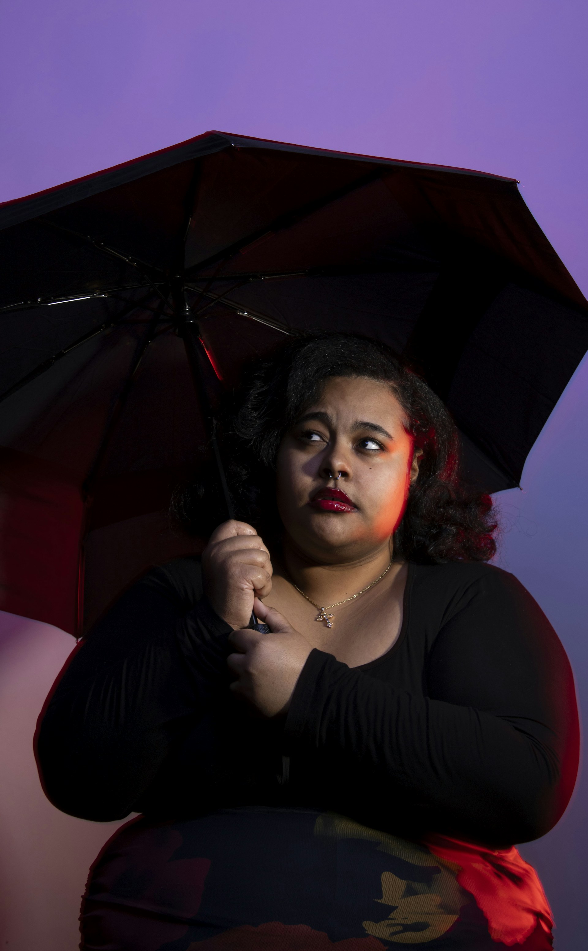 A woman holds an umbrella in the dim lighting.