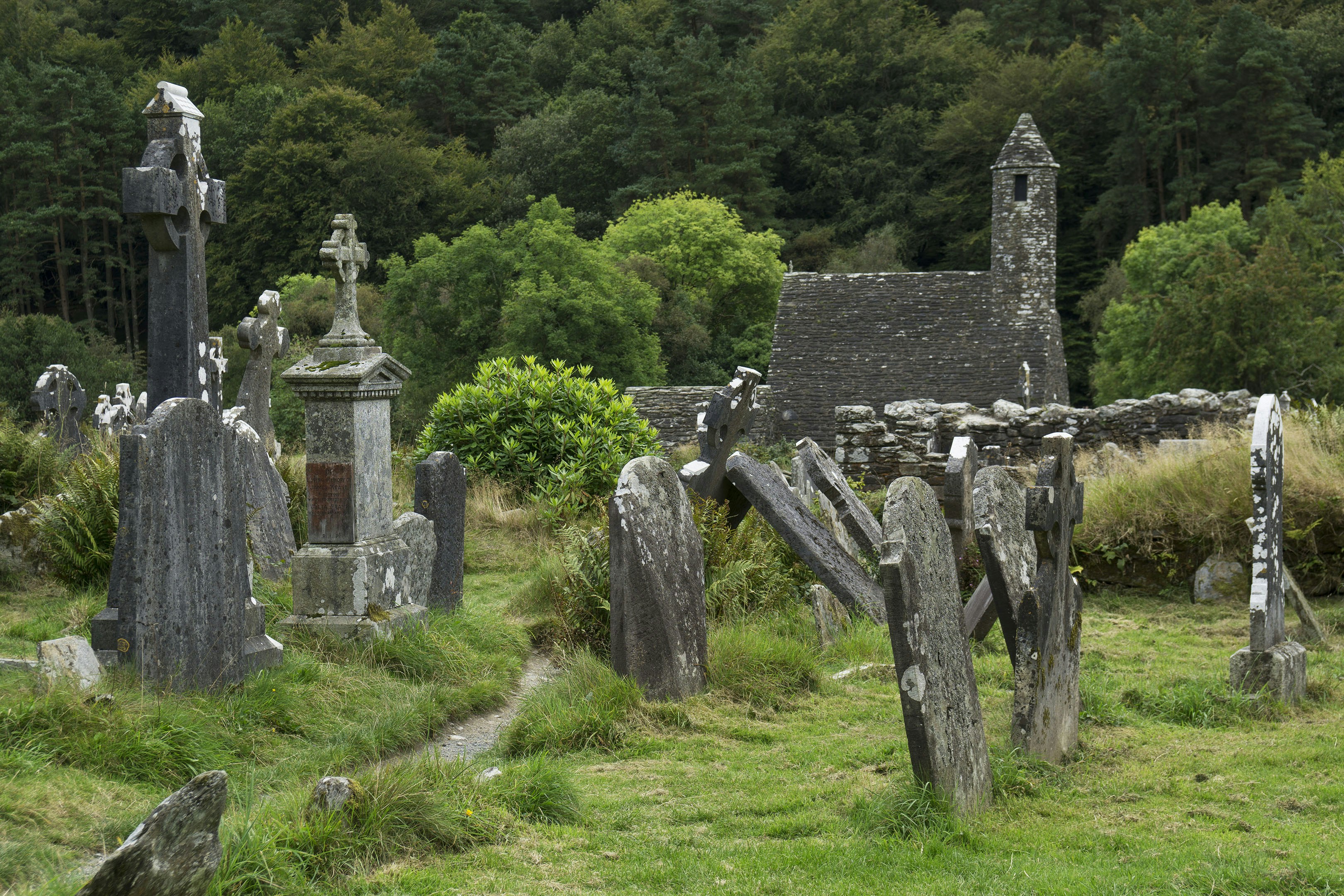 Un ancien cimetière avec des croix en pierre et une église.