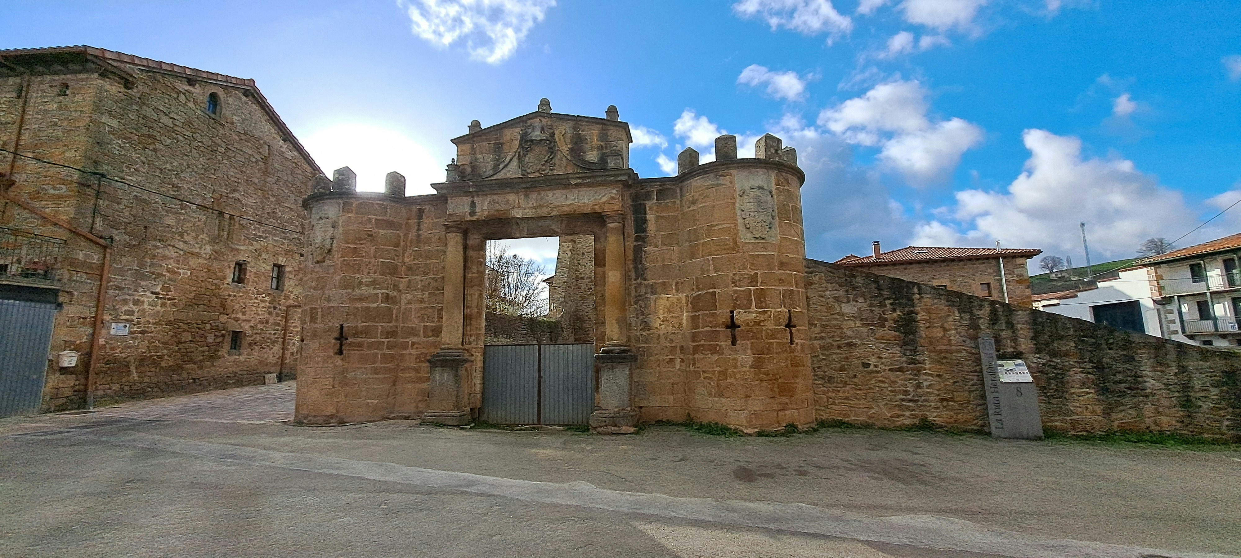 A stone gate and wall under a blue sky.