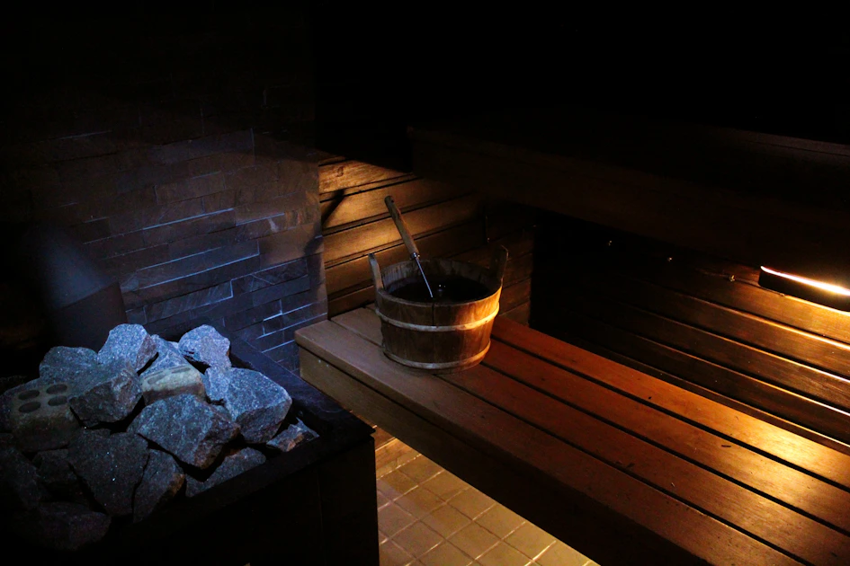 traditional sauna interior with stone heater and wooden bucket