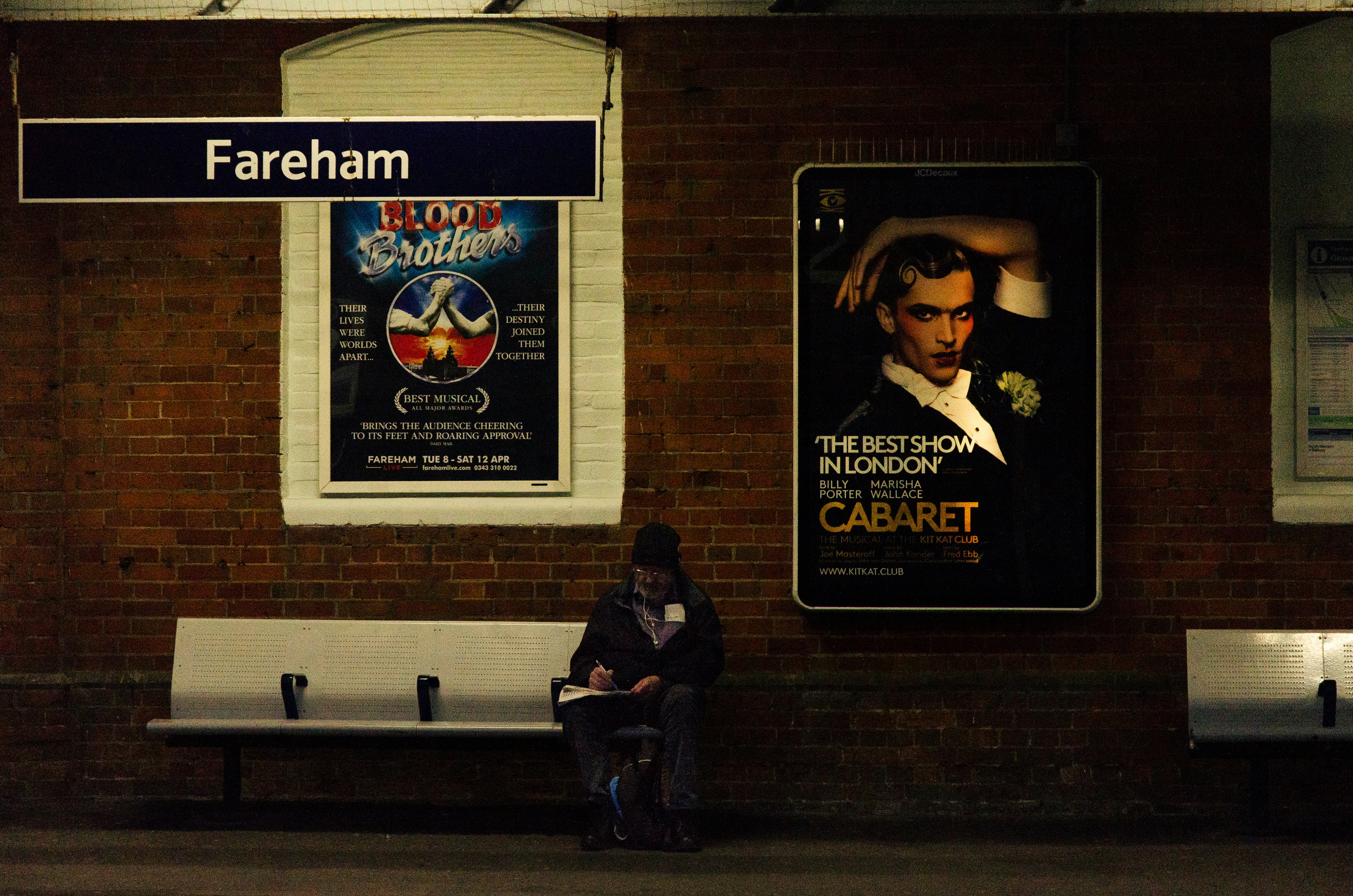 Eine Person sitzt an der Fareham-Station.