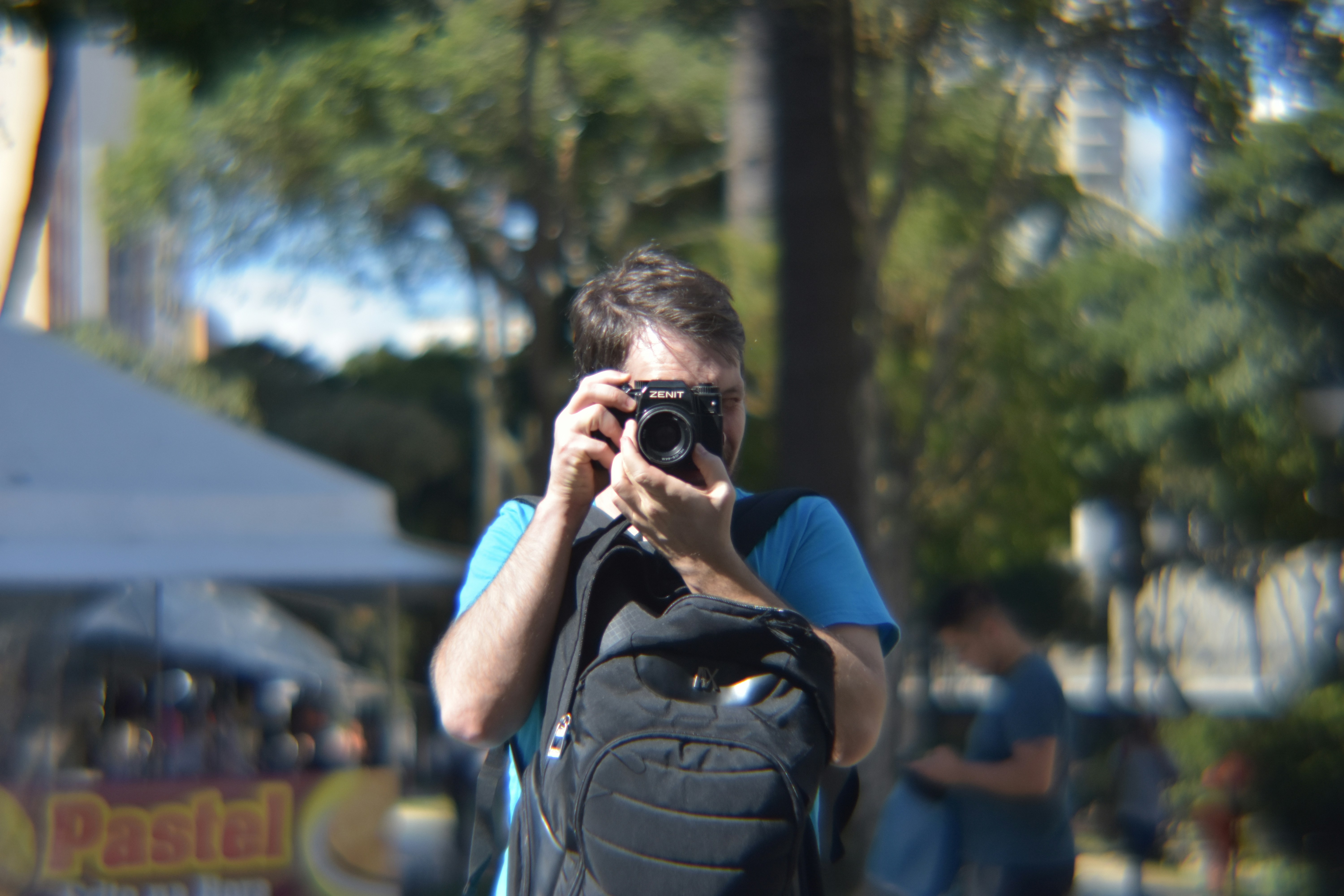 A man is photographing outdoors with a camera.